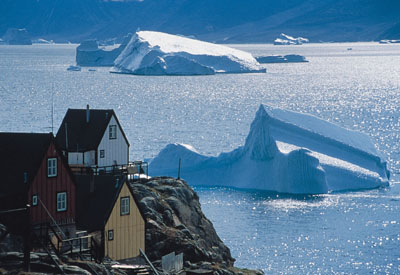Arktis, Grönland: Wunderwelt der Eisberge - Grönland's Westen - Schwimmende Eisberge ziehen an einer kleinen Siedlung vorbei